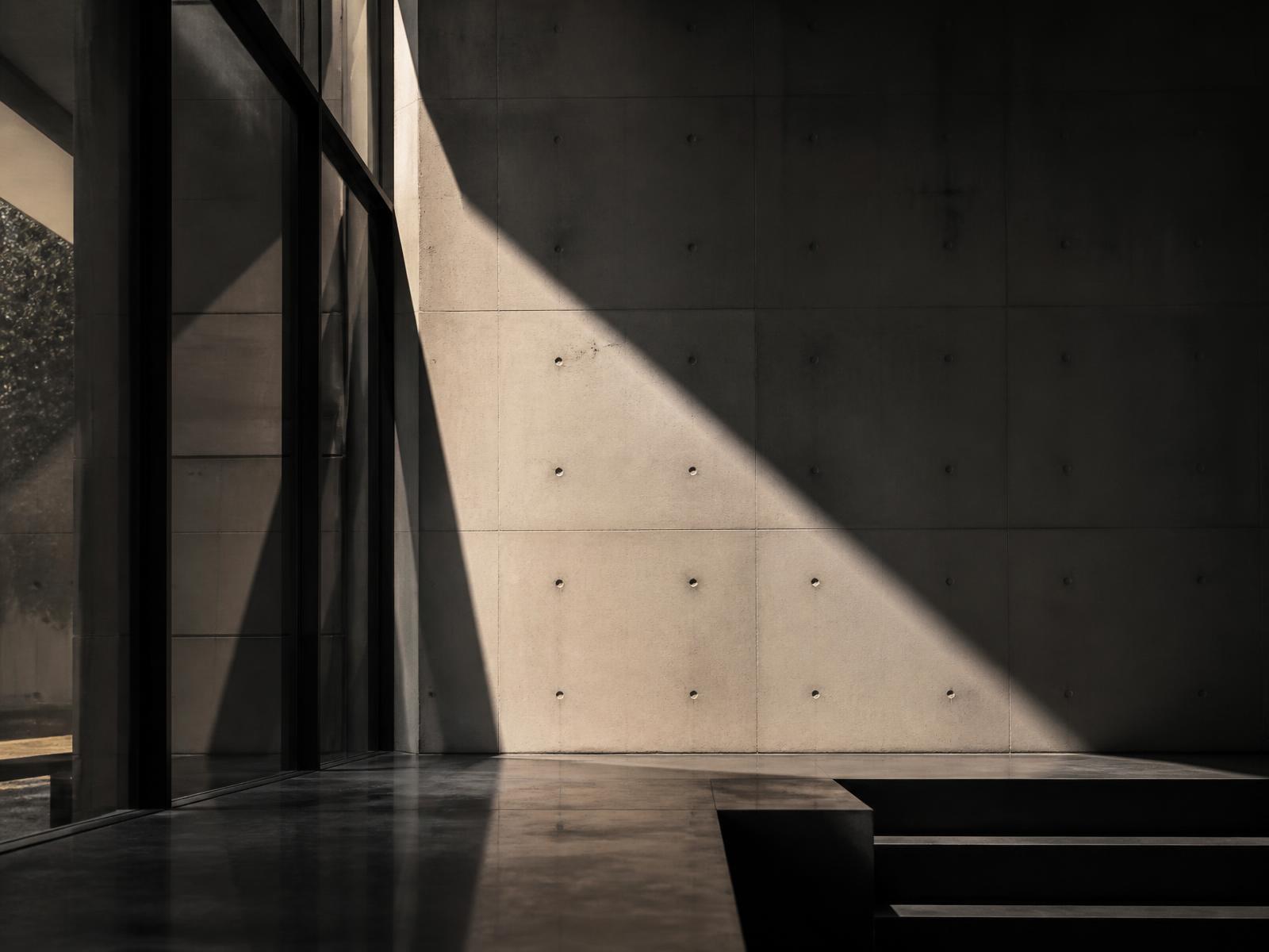 Interior de hormigón y vidrio con luz arquitectónica